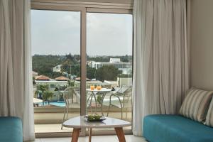 a living room with a couch and a view of a balcony at Atlantica Aeneas Resort in Ayia Napa