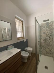 La salle de bains est pourvue de toilettes, d'un lavabo et d'une douche. dans l'établissement Villino Oleandro, à Santa Maria Del Focallo