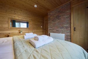 a bedroom with a large bed with towels on it at Fieldfare Lodge with Hot-tub in Carlisle +8 photos