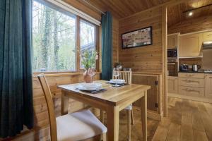 a wooden kitchen with a table and a window at Fieldfare Lodge with Hot-tub in Carlisle