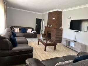 a living room with two couches and a fireplace at Impeccable 3-Bed House in Harare in Harare