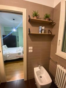 ein Bad mit einem Waschbecken und ein Bett in einem Zimmer in der Unterkunft Casa del Porto in Pesaro