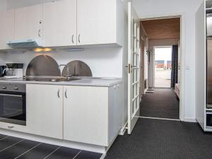 5 person holiday home in R m في Sønderby: مطبخ بدولاب بيضاء وممر مفتوح