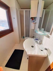 a bathroom with a white sink and a mirror at Biancaneve - 300 Metri dalle Piste, Free Parking e Wi-Fi in Passo del Tonale