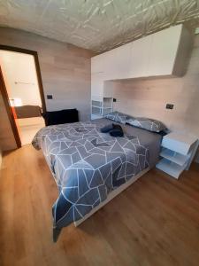 a bedroom with a bed with a blue comforter at Biancaneve - 300 Metri dalle Piste, Free Parking e Wi-Fi in Passo del Tonale