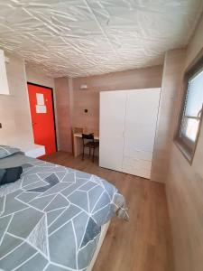1 dormitorio con 1 cama y puerta roja en Biancaneve - 300 Metri dalle Piste, Free Parking e Wi-Fi, en Passo del Tonale