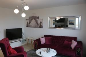 een woonkamer met een rode bank en een tv bij Haut de gamme 4P GARE EVRY 2 in Courcouronnes