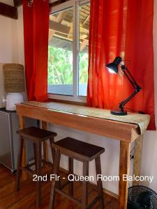 a desk with a lamp in front of a window at Wayans Siargao in General Luna