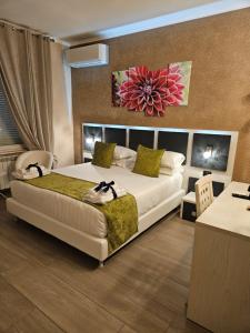 a bedroom with a large bed with a flower painting on the wall at Albis Rooms Guest House in Fiumicino
