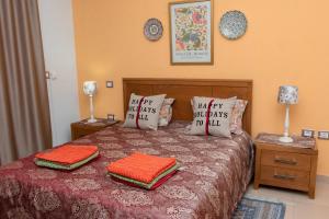 a bedroom with a bed with two pillows on it at Dar Marrakech Apartment Sousse in Hammam Sousse