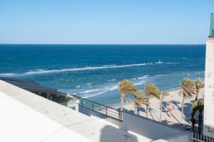 uma vista para uma praia com palmeiras e para o oceano em Dar Marrakech Apartment Sousse em Hammam Sousse