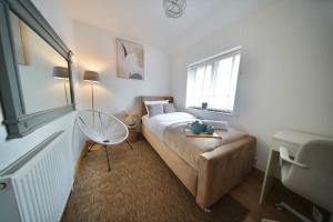 a bedroom with a bed and a chair and a window at Cosy Home- Sleeps 5+City Centre+ Netflix+Free Park in Birmingham