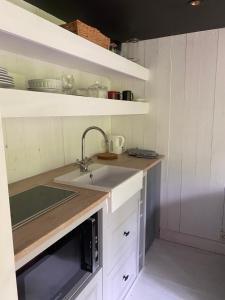 a small kitchen with a sink and a microwave at La Kabane des Hetres rouges in Spa