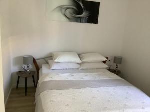 a bedroom with a bed with white sheets and pillows at Apartment 877-2 in Bibinje