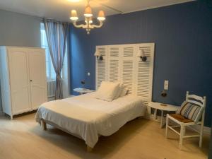 1 dormitorio con 1 cama blanca y 1 silla en Hôtel Les Thermes, en Jonzac