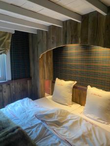 an empty bed with two pillows on top of it at La Kabane des Hetres rouges in Spa