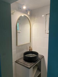 a bathroom with a black sink and a mirror at La Kabane des Hetres rouges in Spa