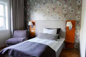 een hotelkamer met een bed en een stoel bij Clarion Hotel Oslo Airport in Gardermoen