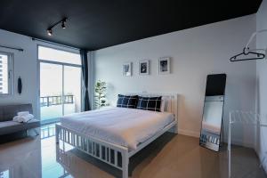 a bedroom with a bed and a large window at Black Turtle in Koh Lone