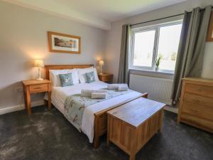 a bedroom with a large bed and a window at Mallard Cottage Lake District, Leisure Spa Pool & Gym in Penruddock