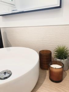 a bathroom with a white tub and a candle at La Palaine, maison à 150m de la mer in La Plaine-sur-Mer