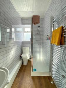 uma casa de banho com um chuveiro, um WC e um lavatório. em Sheffield's 3BR Retreat em Hillsborough