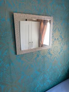 um espelho numa parede com papel de parede azul em Jules Homestay Plus em Ocker Hill