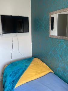 um quarto com uma cama e uma televisão de ecrã plano em Jules Homestay Plus em Ocker Hill