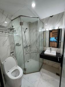 uma casa de banho com um chuveiro, um WC e um lavatório. em HKG-Căn hộ Cầu Giấy em Hanói
