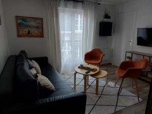 a living room with a couch and a table at Home St. Germain in Trouville-sur-Mer