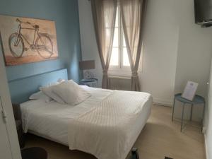 1 dormitorio con 1 cama con una bicicleta en la pared en Hôtel Les Thermes, en Jonzac