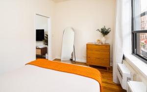 a bedroom with a bed and a dresser and a mirror at Cozy and Modern One-Bedroom Apartment in New York