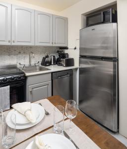 a kitchen with a wooden table with a stainless steel refrigerator at Cozy and Modern One-Bedroom Apartment in New York