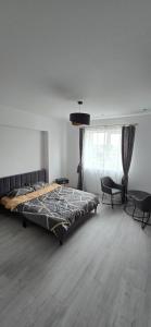 Un dormitorio con una cama y una mesa y sillas. en Camera de Inchiriat in Rin Grand Hotel, en Bucarest 3 fotos más