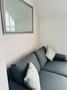 Sofá gris en una habitación con espejo en Penthouse Suite, Central St Leonards, Sea View, en St. Leonards
