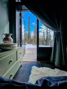 Zimmer mit einem großen Fenster mit Blick auf einen verschneiten Hof in der Unterkunft Cozy Mountain Cottage with beautiful views & Sauna in Beitostøl