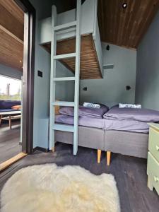 a bedroom with two bunk beds and a ladder at Cozy Mountain Cottage with jacuzzi & Sauna in Beitostøl