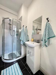 bagno bianco con doccia e lavandino di Little Dockray 1 Bed Apartment a Penrith