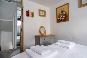 ミルデンホールにあるWits End Cottageのベッドルーム1室(白いシーツとタオル付きのベッド1台付)
