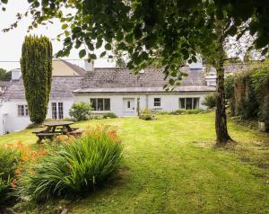 ein weißes Haus mit einem Picknicktisch im Hof in der Unterkunft White Cottage Newport, Pembrokeshire in Newport