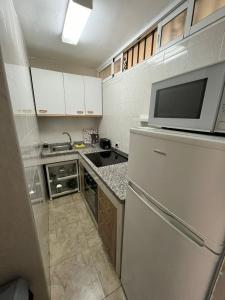 małą kuchnię z lodówką i kuchenką mikrofalową w obiekcie Apartamento Familiar w mieście Benalmádena