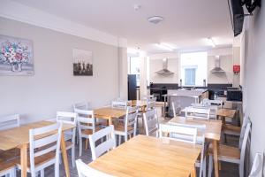 a dining room with wooden tables and white chairs at Avondale House Mulranny in Mulranny
