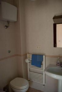 a bathroom with a white toilet and a sink at Una casa accogliente per il tuo soggiorno in Barletta