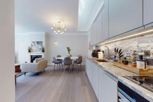 Amazing Newly Refurbished Mews House in W1 في لندن: مطبخ مع طاولة وغرفة طعام