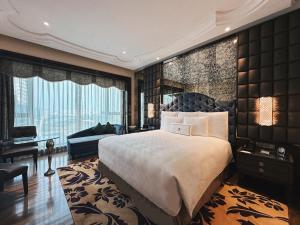 a bedroom with a large bed and a large window at The Reverie Saigon in Ho Chi Minh City