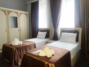 twee bedden in een hotelkamer met handdoeken erop bij Eco soffia Hotel in Baku