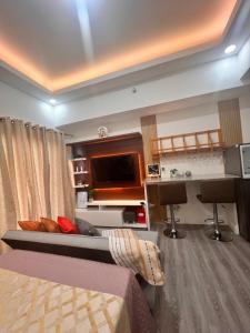 ein Hotelzimmer mit einem Bett und einem Flachbild-TV in der Unterkunft Amani Grand Citygate at the back of Gaisano Milan in Davao City