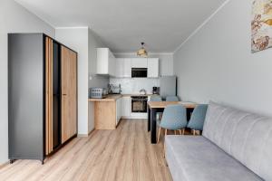 cocina y sala de estar con mesa y sillas en Wejhera by Comfort Apartments, en Jelitkowo