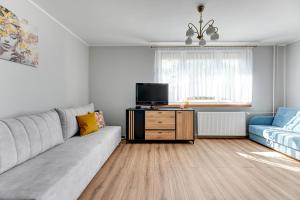 sala de estar con sofá y TV en Wejhera by Comfort Apartments, en Jelitkowo