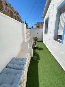 un patio con erba verde accanto a un edificio bianco di PEPE a Denia